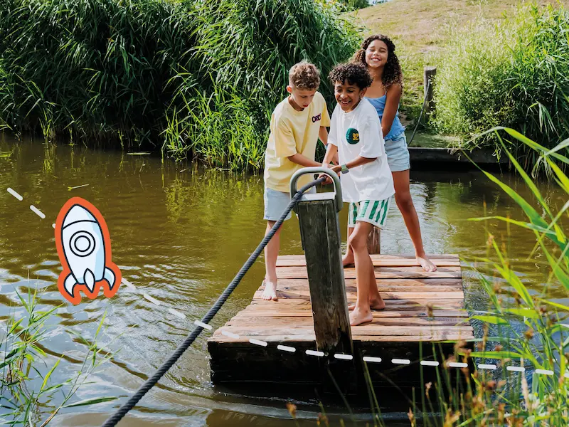 Kinder spielen an einem See an einer Wasserstelle und tragen GPS-Uhren