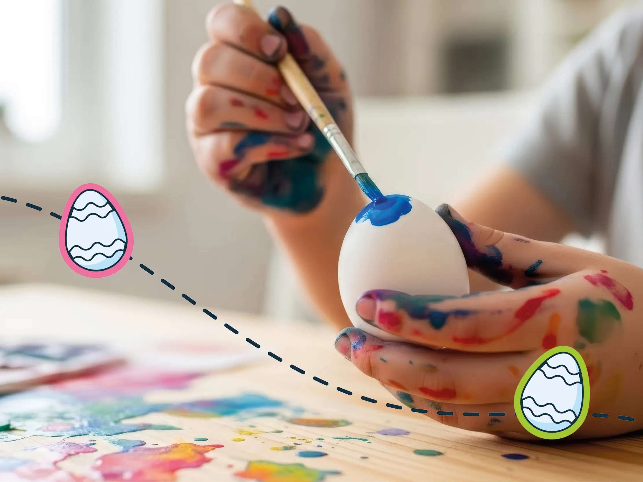Kind bemalt ein Osterei mit blauer Farbe – Ostereier basteln und bemalen zu Ostern.