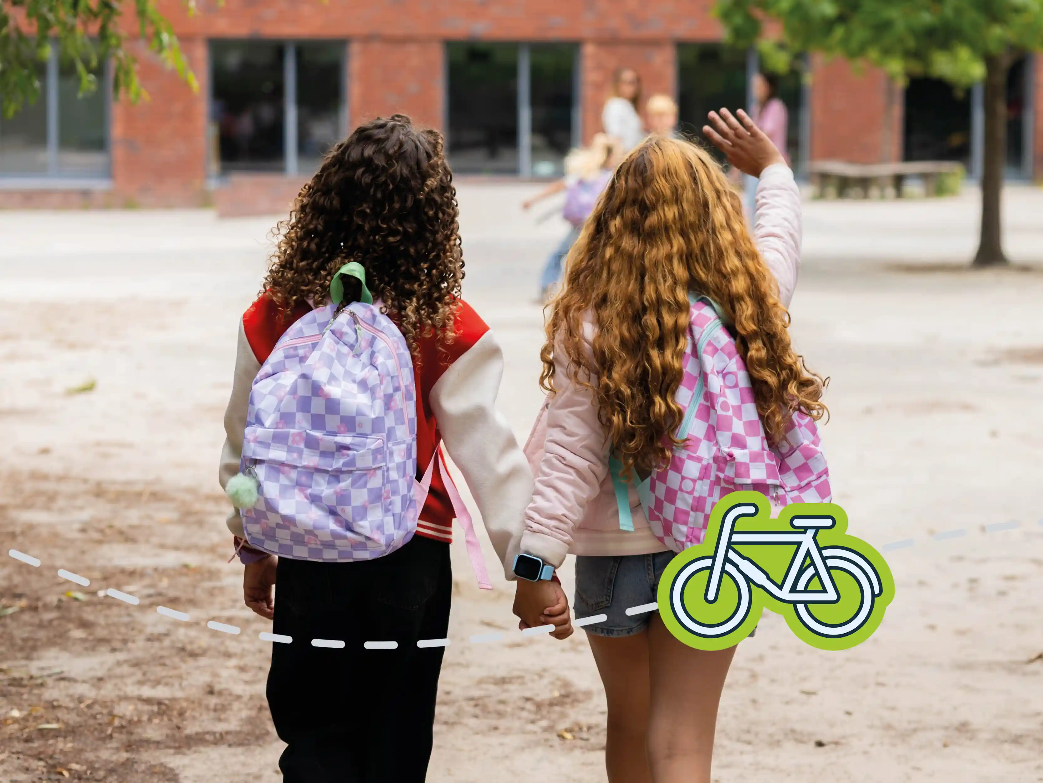 Zwei Kinder gehen mit ihren Schulrucksäcken entspannt zur Schule.